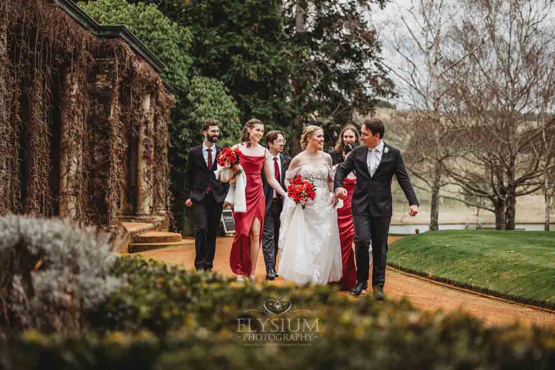 The bridal party walk together down the driveway at Bendooley Book Barn during a winter wedding